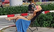 Khó hiểu với người phụ nữ ăn mặc mát mẻ ngồi phơi nắng giữa đường lớn