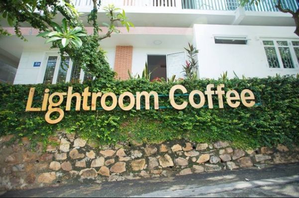 Lightroom Coffee Studio ghi điểm với bức tường được phủ xanh bởi lá cây ngay tại cổng vào. 
